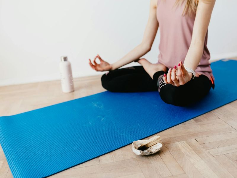 Beautifully arranged yoga mat and incense in a room.